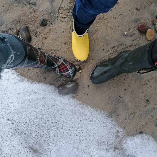 Drei-paar-stiefel-am-strand